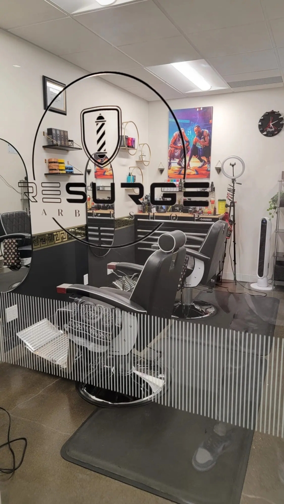 photo of resurge barbershop enviroment. Two chairs and stations set up with decorations on wall